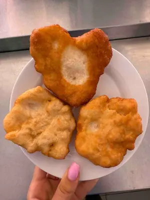 a person holding a plate with three pieces of food at Complex Terazini in Byala