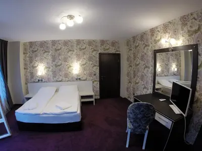 a hotel room with a bed and a mirror at VIP Apartments Dobrevi in Primorsko