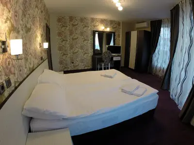 a bedroom with a large white bed in a room at VIP Apartments Dobrevi in Primorsko