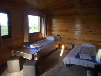 a room with two beds and a table and two windows at Lozyata Guest House in Obzor