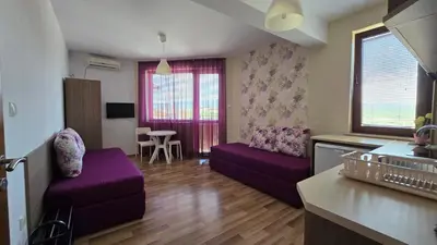 a living room with purple couches and a kitchen at Estreya in Tsarevo