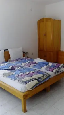 a bed with a wooden frame with clothes on it at Lurd Family Hotel in Lozenets