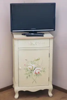 a television on top of a dresser with flowers on it at Beach Apartment MELINA in Pomorie