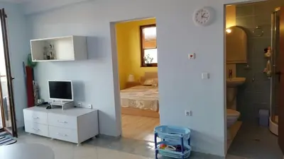 a bedroom with a bed and a television and a bathroom at Apartments Resort BG in Primorsko