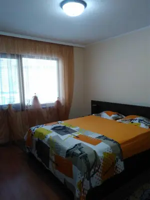 a bedroom with a bed with a blanket on it at Dom Eli in Pomorie