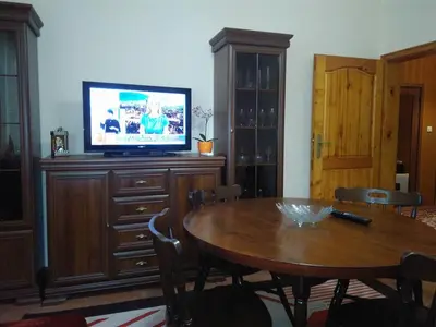 a living room with a table and a television on a cabinet at Dom Eli in Pomorie