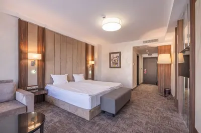 a hotel room with a bed and a couch at Grand Hotel Sveti Vlas - Fitness & SPA Hotel in Sveti Vlas