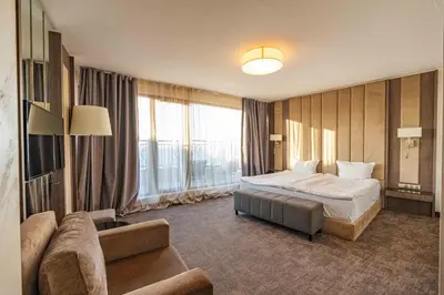 a hotel room with a bed and a couch at Grand Hotel Sveti Vlas - Fitness & SPA Hotel in Sveti Vlas