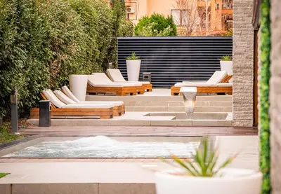 a patio with lounge chairs and a fountain at Grand Hotel Sveti Vlas - Fitness & SPA Hotel in Sveti Vlas