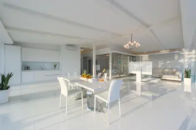 a white kitchen with a white table and chairs at Grand Hotel Sveti Vlas - Fitness & SPA Hotel in Sveti Vlas