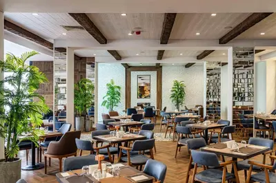 a restaurant with tables and chairs and plants at Grand Hotel Sveti Vlas - Fitness & SPA Hotel in Sveti Vlas
