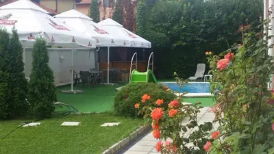 a backyard with a swimming pool with umbrellas and a yard at Aparthotel Lucky Family in Ravda