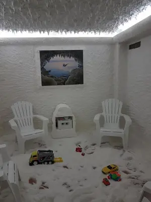 a room with two white chairs and toys in the sand at Aparthotel Lucky Family in Ravda