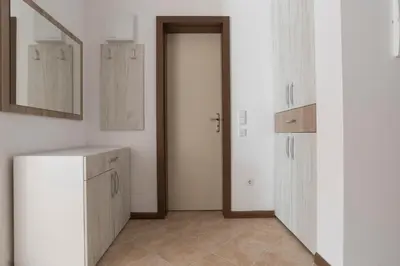 a room with white cabinets and a door with a mirror at Oasis Resort & Spa Cozy Apartments in Lozenets