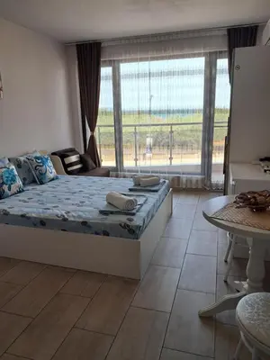 a bedroom with a bed and a large window at Apart Hotel Iglika in Pomorie