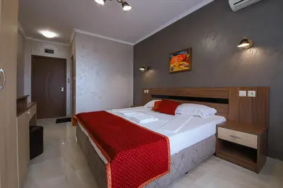 a bedroom with a large bed with a red blanket at Guesthouse Phoenix in Obzor