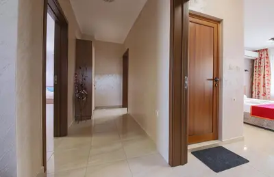 a hallway with a wooden door in a house at Guesthouse Phoenix in Obzor