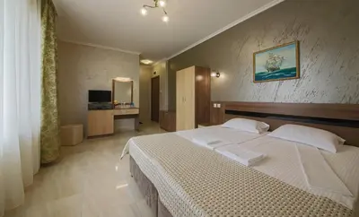 a hotel room with a bed and a television at Guesthouse Phoenix in Obzor