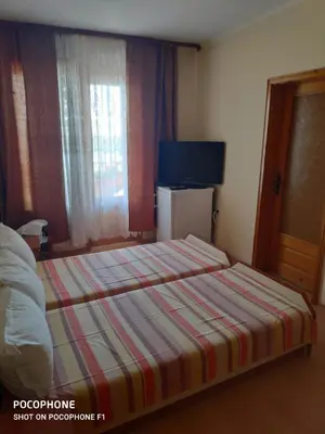 a hotel room with a bed with a striped blanket at Homestay Kostadinov in Pomorie
