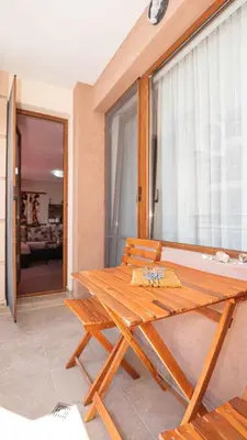 a wooden picnic table and chairs in a room at Flat Lora Pomorie in Pomorie