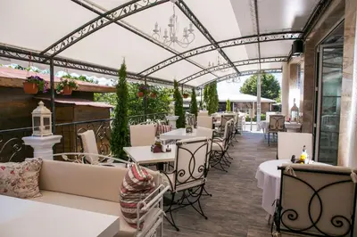 a restaurant with white tables and chairs and a glass ceiling at семеен хотел Прованс Ахелой in Aheloy