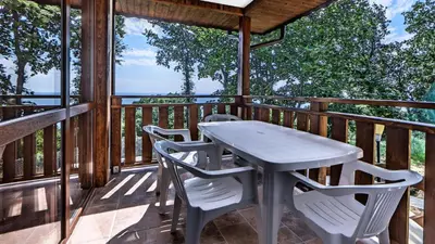 a table and chairs on the deck of a cabin at Complex Fichoza in Varna City