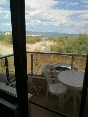 a balcony with a table and chairs and a view of the ocean at Sunshine Apartment in Pomorie