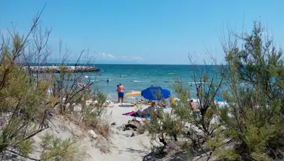 a group of people on a beach with an umbrella at Sunshine Apartment in Pomorie