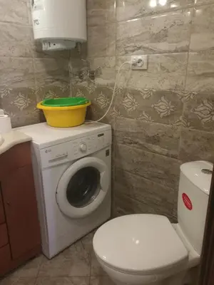 a bathroom with a toilet and a washing machine at Sunshine Apartment in Pomorie