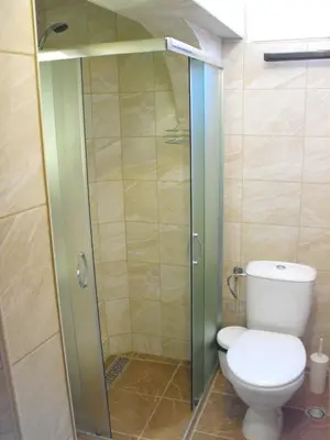 a bathroom with a toilet and a glass shower stall at Julia Garden in Burgas City