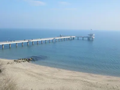 a pier in the water next to a beach at Julia Garden in Burgas City