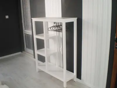 a white book shelf in the corner of a room at Draga Apartment in Nesebar