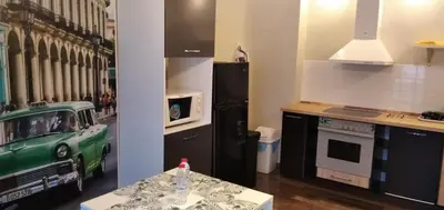 a kitchen with a stove and a refrigerator and a table at Draga Apartment in Nesebar