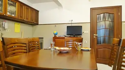 a kitchen with a wooden table and a television at Apartment Kafedral in Varna City