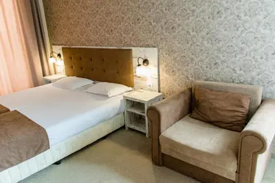 a hotel room with a bed and a chair at Paraiso Theopolis - All Inclusive in Obzor
