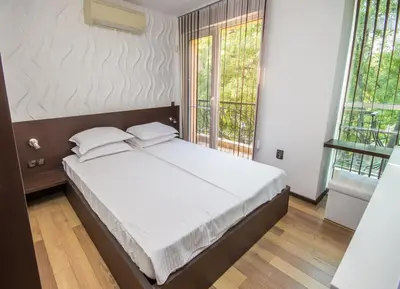 a bedroom with a bed with white sheets and two pillows at City Apartments La Casa in Varna City