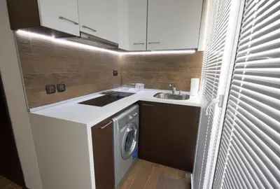 a kitchen with a sink and a washing machine at City Apartments La Casa in Varna City