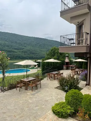 a patio with tables and umbrellas next to a pool at Eco House Kitana in Tschenge