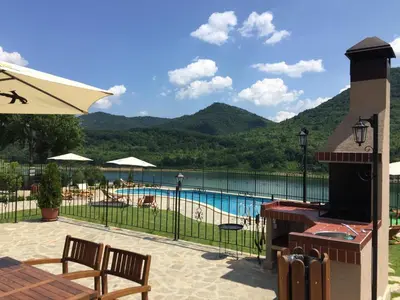 a resort with a swimming pool and mountains in the background at Eco House Kitana in Tschenge