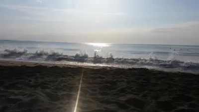 a beach with the ocean and water spraying up at 4U Apartment in Burgas City