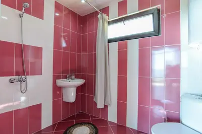 a bathroom with a pink and white striped wall at Galata Residence in Varna City