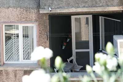 an open door with a chair on the porch at Apartment Balabanov in Varna City