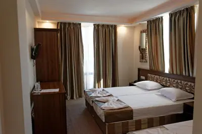 a hotel room with two beds and a television at Hotel Aristokrat in Obzor
