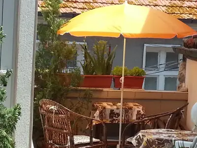 a table with a yellow umbrella on a patio at Sadala Guest House in Nesebar