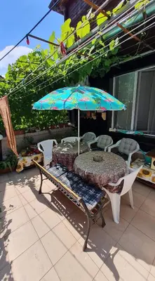 a table and chairs and an umbrella on a patio at Sadala Guest House in Nesebar