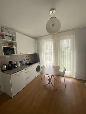 a kitchen with a wooden table and a table and chairs at Belvedere Apartments in Byala