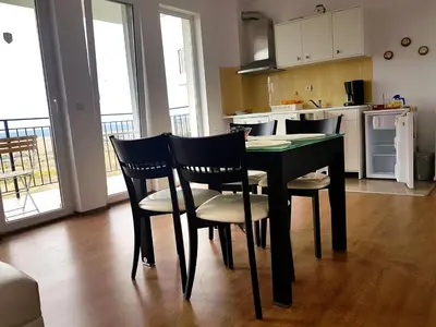 a kitchen with a black table and chairs and a kitchen with a kitchen at Belvedere Apartments in Byala