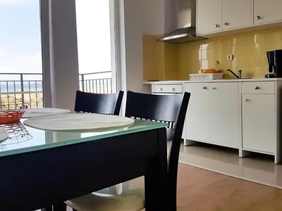 a kitchen and dining room with a table and chairs at Belvedere Apartments in Byala