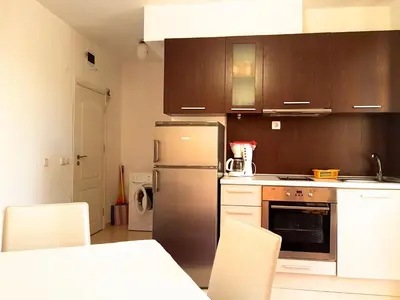 a kitchen with a stainless steel refrigerator and white cabinets at Belvedere Apartments in Byala