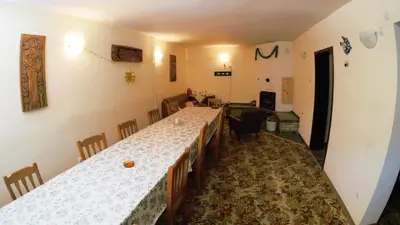 a dining room with a long table and a living room at Atanasovi House in Shkorpilovtsi
